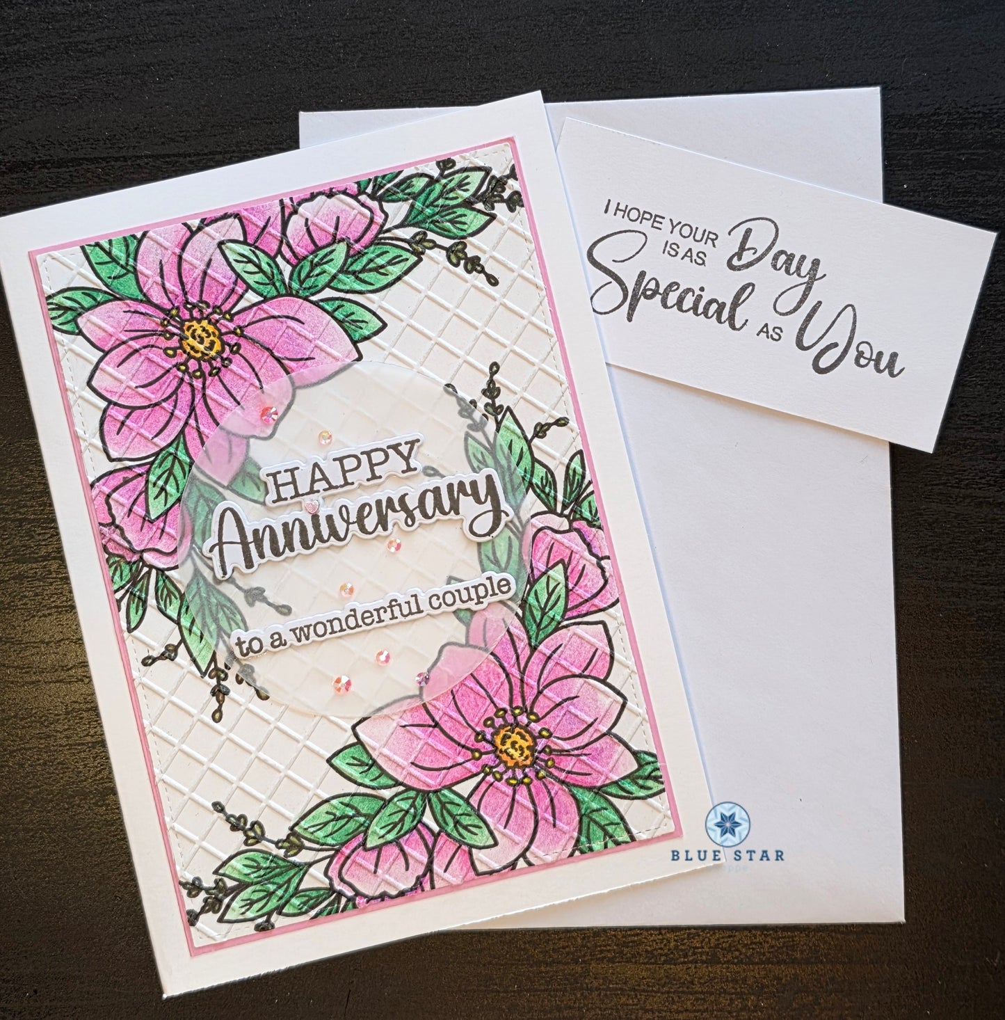 Anniversary card with pink flowers and green leaves on a white background