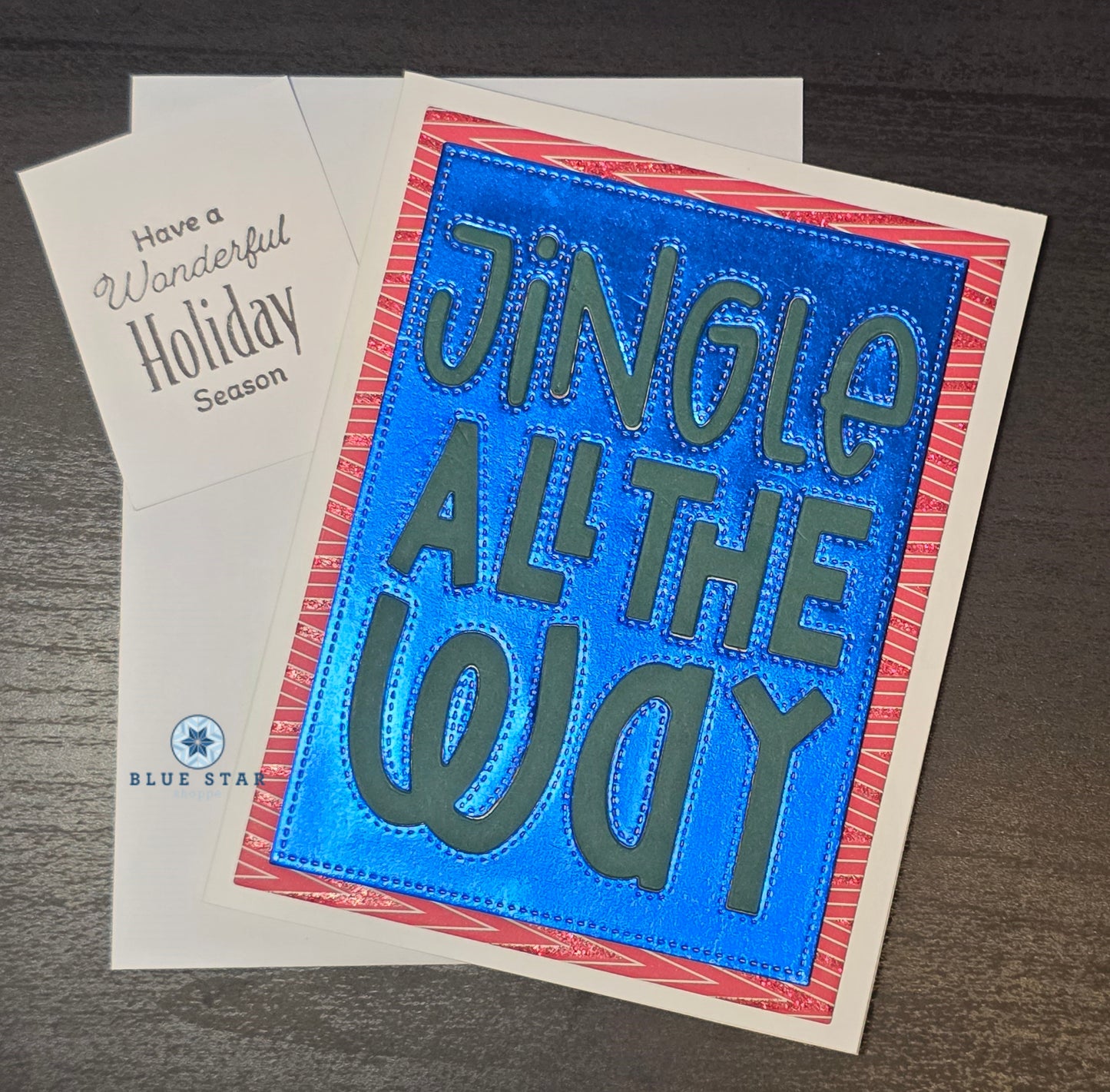 Holiday card with 'Jingle All The Way' text on a blue background