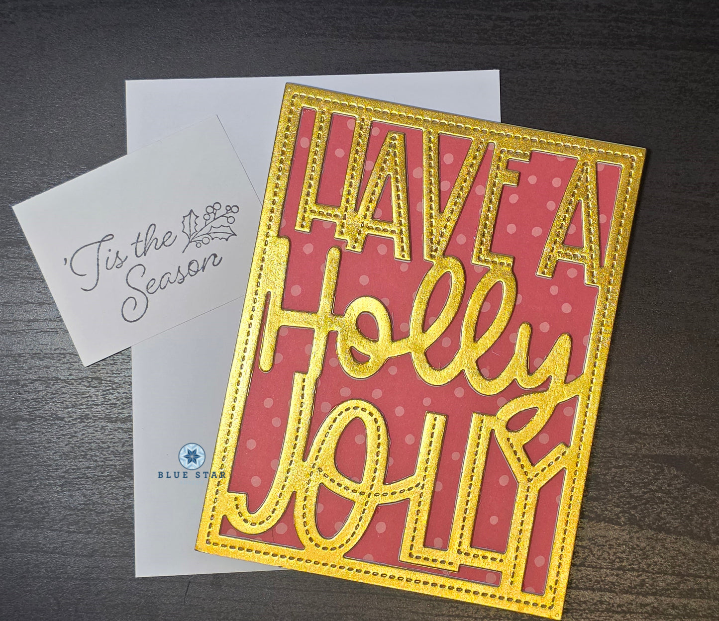 Greeting card with 'Have a Holly Jolly' text on a red background, with an envelope labeled 'Tis the Season'.