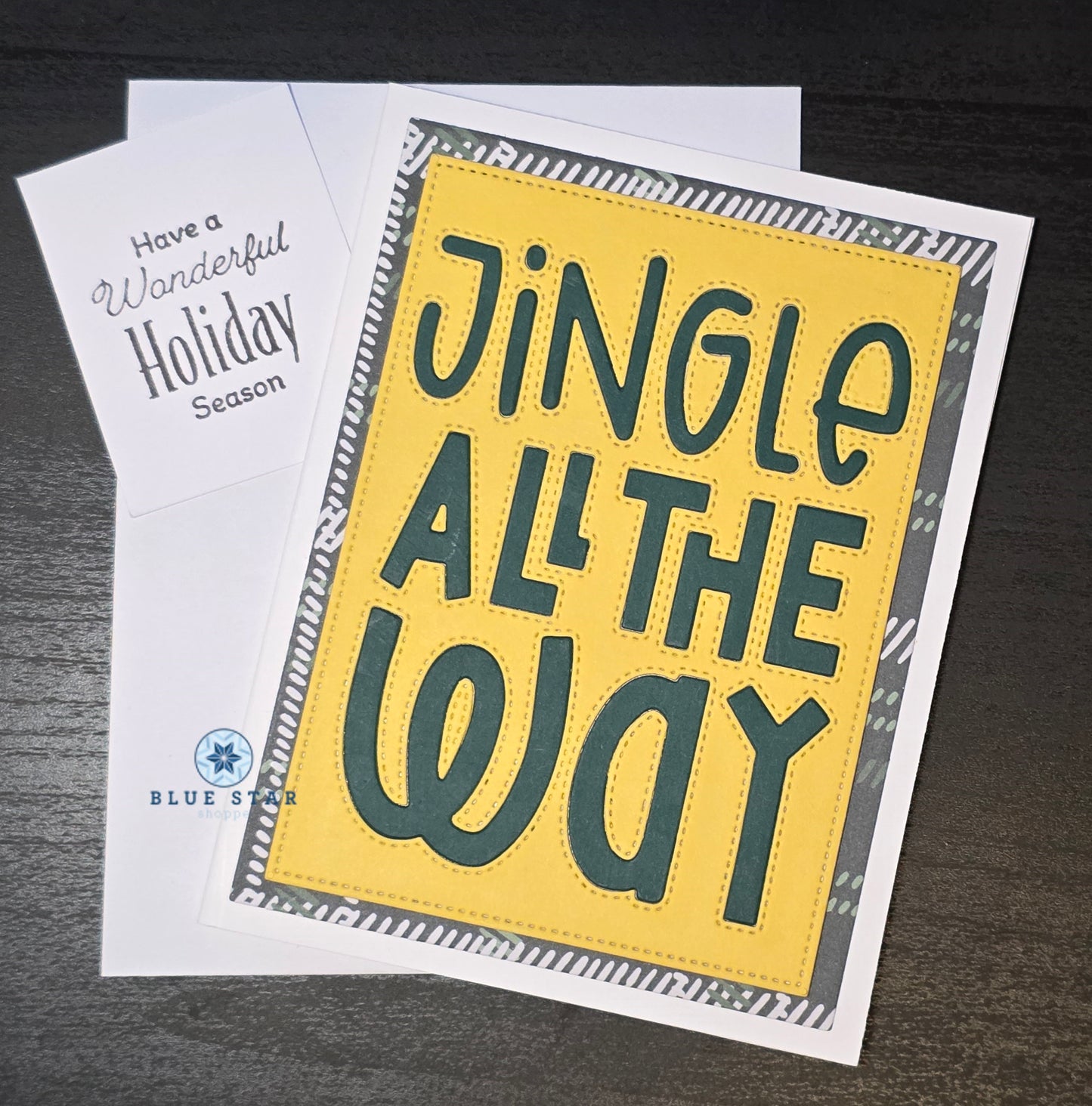 Holiday card with 'Jingle All The Way' text on a yellow background